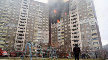 Un agente de la ley se encuentra junto a un edificio residencial dañado como resultado de un ataque con misiles en Kiev el 7 de febrero de 2024, en medio de la invasión rusa de Ucrania.&nbsp;