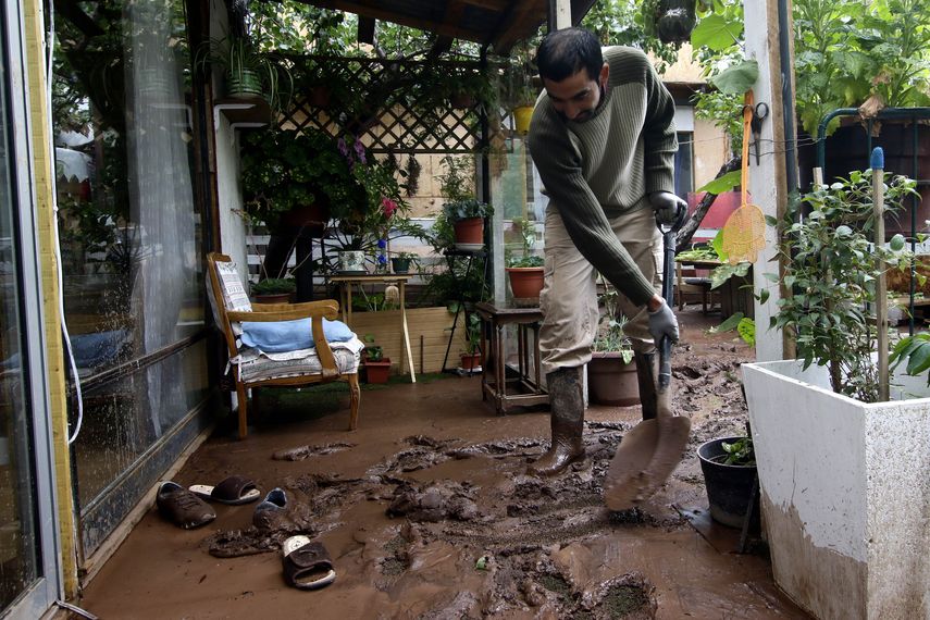 Un hombre limpiando el barro de su casa en Lo Barnechea, en las afueras de Santiago de Chile, el 1 de febrero de 2021, un día después de que un deslizamiento de tierra afectara un tramo del Camino a Farellones y sus alrededores.