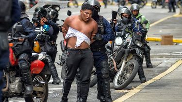 Miembros de la Policía Nacional Bolivariana detienen a un hombre durante una manifestación convocada por la oposición en el barrio Chacao de Caracas el 30 de julio de 2024. Las fuerzas de seguridad dispararon gases lacrimógenos y balas de goma contra los manifestantes y una ONG dijo que 11 personas han muerto y decenas más han sido asesinadas.  