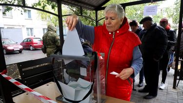 Una mujer deposita su voto durante un referéndum en un colegio electoral móvil en Mariúpol, en la región ucraniana de Donetsk, controlada por separatistas respaldados por Rusia, el viernes 23 de septiembre de 2022.&nbsp;