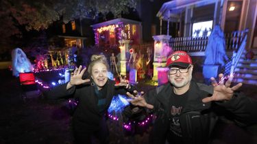 Fotografía&nbsp;del 29 de octubre del 2019 de&nbsp;dos personas que posan para una foto en las afueras de sus casas en Bernard Street, Chicago, decoradas para Halloween.