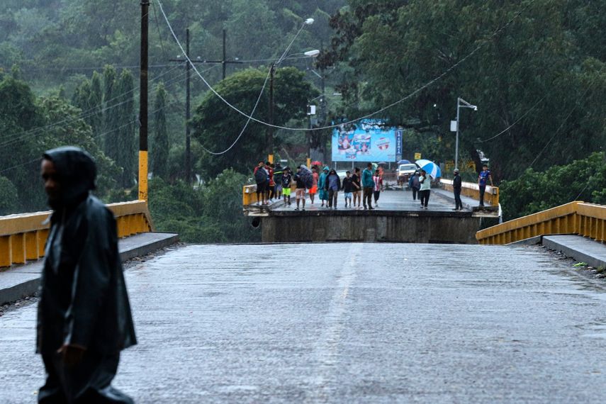 La gente se encuentra en el puente Saopin, destruido por el creciente caudal del río Cangrajal tras el paso de la tormenta tropical Sara en La Ceiba, Honduras, el 15 de noviembre de 2024.