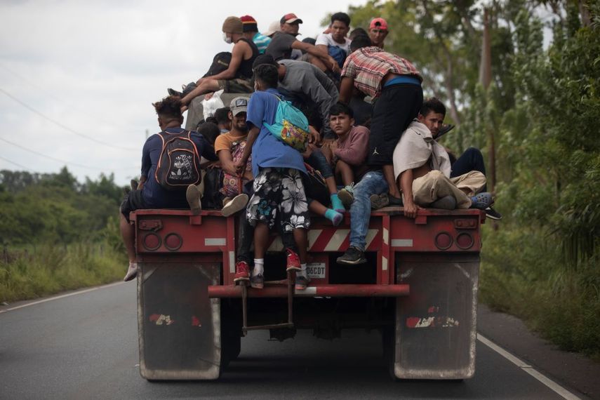 En esta fotografía de archivo del 2 de octubre de 2020, los migrantes viajan en la parte trasera de un camión de carga que redujo la velocidad para darles la oportunidad de subirse a los migrantes en su trayectoria.&nbsp;