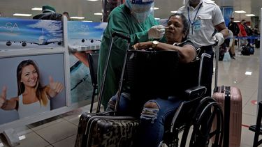 El personal de salud cubano recoge una muestra con hisopo para una prueba de COVID-19 a un pasajero en silla de ruedas en el Aeropuerto Internacional José Martí.&nbsp;