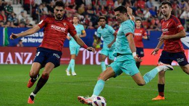 Robert Lewandowski del Barcelona dispara el balón superando a Alejandro Catena del Osasuna en el encuentro de la liga española, el domingo 3 de septiembre del 2023.