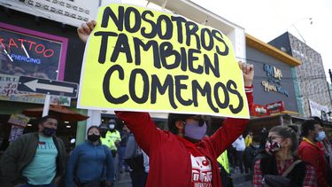 Un hombre sostiene un cartel durante una protesta para exigir el derecho a trabajar durante una cuarentena para evitar más contagios del nuevo coronavirus en Bogotá, Colombia, el viernes 29 de enero de 2021