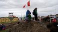 &nbsp;Una mujer aymara con una bandera peruana se para sobre un montículo de tierra que sirve de barricada en un camino instalada por manifestantes contra el gobierno en Acora, sur de Perú, 29 de enero de 2023.