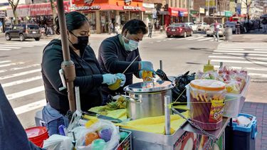 Ruth Palacios (izq) y su esposo Arturo Xelo trabajando en un puesto callejero de venta de frutas en el barrio de Corona, en Queens, Nueva York.