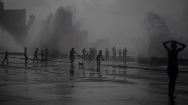 La gente juega en las olas que rompen en el Malecón, después del huracán Ian en La Habana, Cuba, el miércoles 28 de septiembre de 2022.