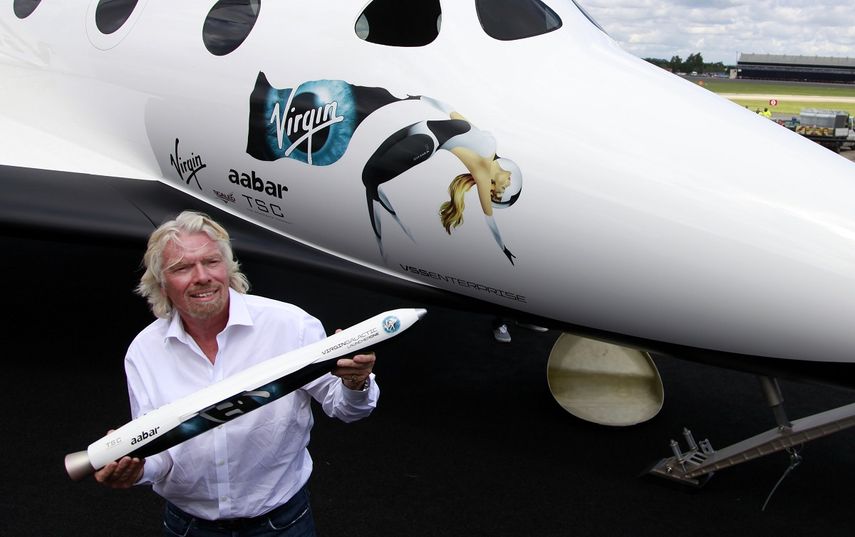 En esta foto de archivo del 11 de julio de 2012, el multimillonario británico Richard Branson sostiene un modelo de LauncherOne, un cohete que se usará para lanzar pequeños satélites al espacio, en el Salón Aeronáutico Internacional de Farnborough en Farnborough, Inglaterra.&nbsp;