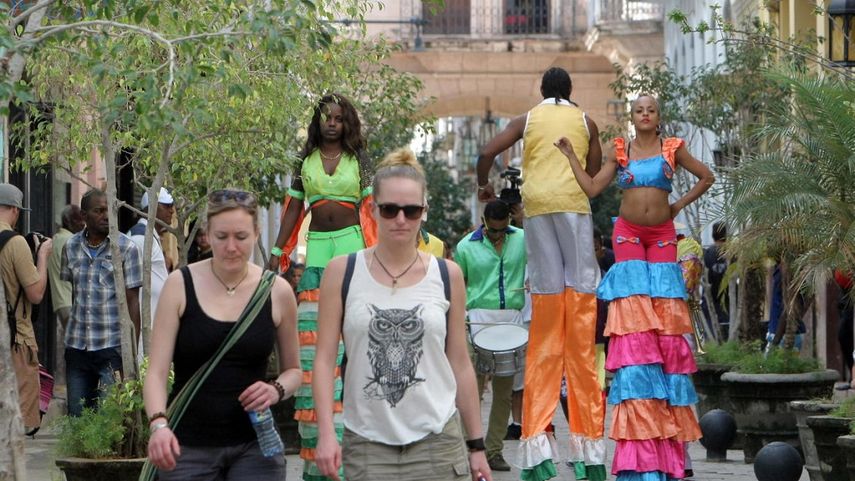 Varios turistas recorren calles de La Habana en medio de un ambiente festivo.