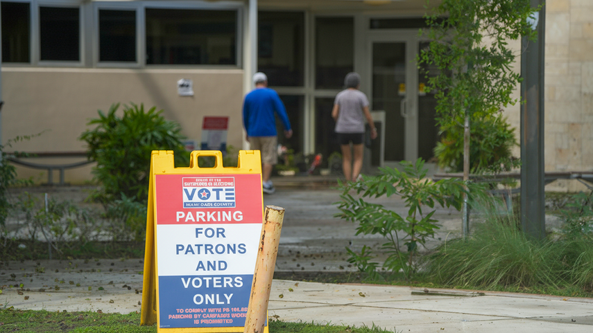 Dos votantes ingresan al precinto electoral habilitado en la biblioteca de Shenandoah, en Miami.