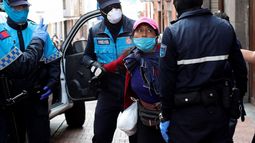 La policía metropolitana detiene a una vendedora de fruta callejera, lo cual está prohibido debido al coronavirus, en Quito, Ecuador, el viernes 10 de abril de 2020. 