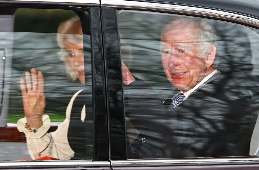 El rey Carlos III de Gran Bretaña y la reina Camilla saludan mientras salen en automóvil desde Clarence House en Londres el 6 de febrero de 2024.