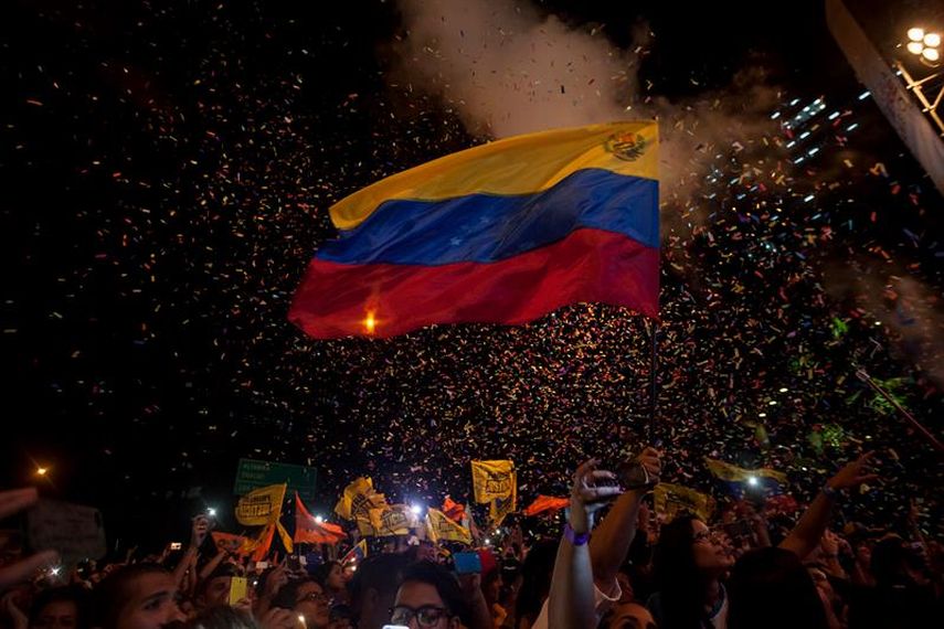 Simpatizantes de la coalición opositora Mesa de Unidad Democratica participan en un acto por el cierre de campaña en Caracas.(EFE)