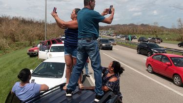 Se espera que al menos 100.000 desplazados lleguen al estado de Florida. En la imagen, varios ciudadanos puertorriqueños tratan de acceder a lugares con cobertura móvil para comunicarse con sus familiares y amigos.