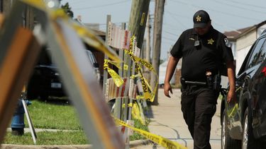 Un policía camina cerca de una casa donde se encontraron dos cadáveres en el patio, en un suburbio de Lyons, Chicago, el 28 de agosto de 2021.