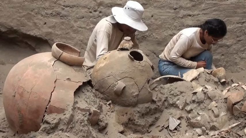 Esta imagen de folleto publicada por la Universidad Nacional Mayor de San Marcos y distribuida el 21 de mayo de 2023 muestra a los trabajadores descubriendo una tumba de 1.000 años de antigüedad de una figura de élite vinculada al mar de la cultura prehispánica Chancay en el sitio arqueológico funerario de Macaton en la costa de la provincia de Huaral, a unos 75 km al norte de Lima, Perú.