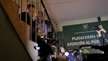 Luis Fernando Camacho (derecha), una figura clave de la oposición y gobernador de la potencia económica de la región de Santa Cruz, es escoltado por una escalera al llegar a la sede de las Fuerzas Especiales de Lucha contra el Crimen (FELCC) en La Paz, Bolivia, tras ser detenido por el régimen del MAS de Evo Morales.