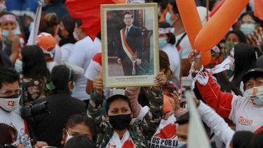 Una partidaria de la candidata presidencial de derecha Keiko Fujimori sostiene un retrato de su padre, el expresidente peruano Alberto Fujimori durante el mitin de clausura de su campaña en Lima, el 3 de junio de 2021.