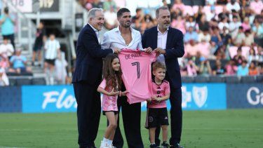 Rodrigo De Paul (centro) posa junto a José y Jorge Mas, copropietarios del Inter Miami CF, en su presentación como nuevo jugador del club, el 26 de julio de 2025 en Fort Lauderdale, Florida.