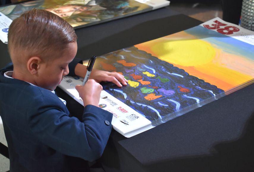 Santiago Niebles firma el flyer que realizó para la celebración del Día Internacional del Niño. 
