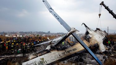 Los bomberos trabajan entre los restos del avión que se estrelló en el aeropuerto de Katmandú (Nepal) .&nbsp;