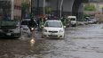 Un conductor en moto y un auto circulan por una calle inundada por las fuertes lluvias en Peshawar, Pakistán, el lunes 15 de abril de 2024. Docenas de personas, la mayoría agricultores, murieron en Pakistán debido a las precipitaciones en los últimos tres días, según dijeron las autoridades el lunes.