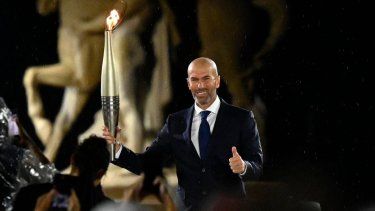 El exjugador de fútbol francés, Zinedine Zidane, sostiene la antorcha olímpica durante la ceremonia de apertura de los Juegos Olímpicos de París, el 26 de julio de 2024.