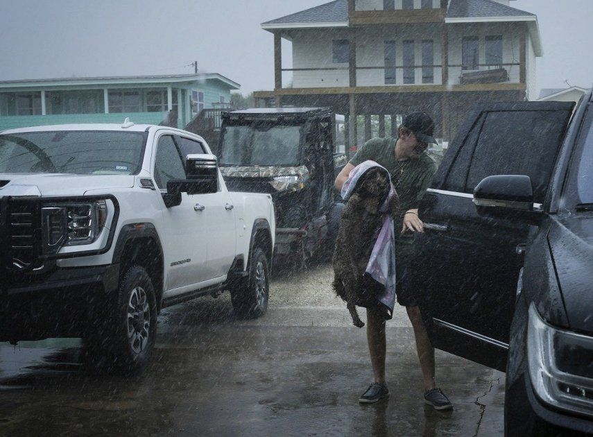 Blake Braunsube a su perra Dolly en el vehículo de su familia mientras las bandas exteriores de la tormenta Beryl comienzan a llegar a la costa el domingo 7 de julio de 2024 en Port O'Connor, Texas.  
