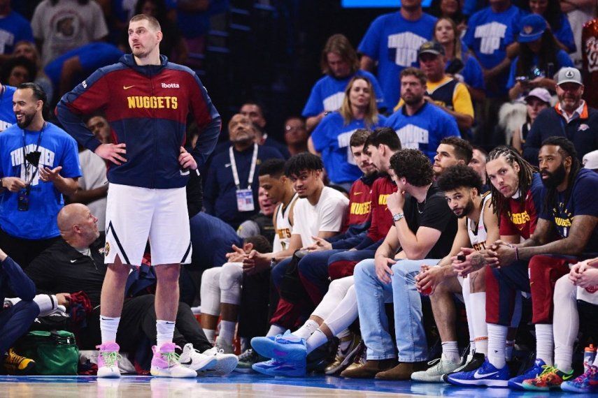 Nikola Jokic (izq) y los titulares de los Nuggets de Denver observan desde la banca durante el último cuarto de un partido contra el Thunder de Oklahoma City, el 18 de mayo de 2025 en Oklahoma City, Oklahoma.