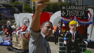 Un hombre se toma una selfie con figuras que representan al presidente Nicol&aacute;s Maduro, al jefe de la Asamblea Nacional Constituyente, Diosdado Cabello y al presidente estadounidense Donald Trump en Caracas, Venezuela, el martes 25 de febrero de 2019.