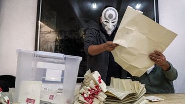 Un trabajador electoral con una máscara del personaje Amon, de la serie animada Leyenda de Korra, cuenta las papeletas después del segundo día de la elección de la Convención Constitucional para seleccionar a los miembros de la asamblea que redactarán una nueva constitución, en Santiago, Chile, el domingo 16 de mayo de 202. &nbsp;