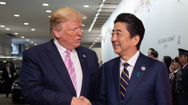 El primer ministro japonés Shinzo Abe (der.) saluda al presidente Donald Trump a su llegada al International Exhibition Center para participar en la Cumbre del G20, en Osaka.