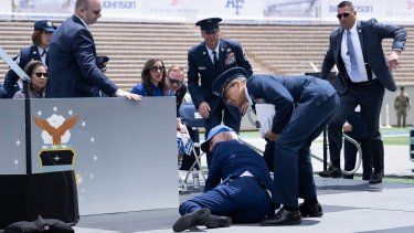 El presidente Joe Biden es auxiliado tras caerse durante un acto de graduación de la Fuerza Aérea, 1 de junio de 2023.