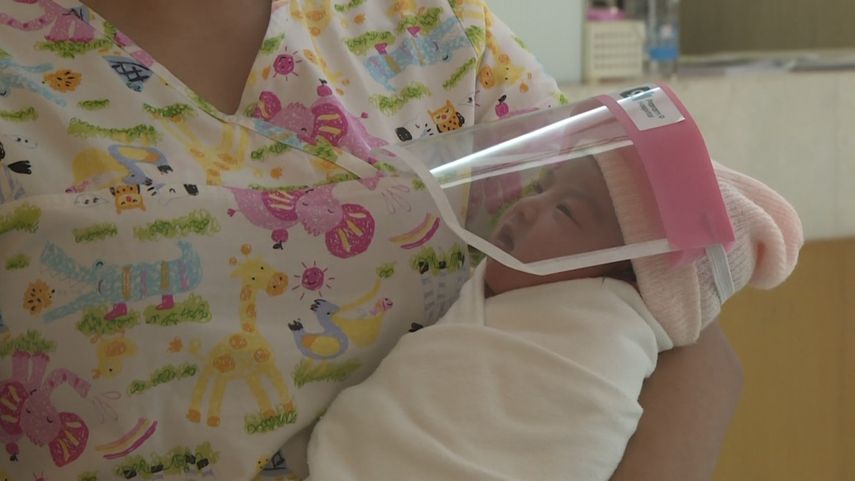 Un beb&eacute; lleva un diminuto protector facial ante el riesgo de contagio de coronavirus en Tailandia.