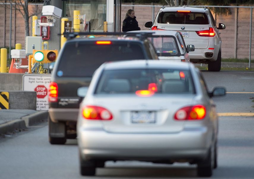 Un oficial de la Agencia de Servicios Fronterizos de Canad&aacute; inspecciona un veh&iacute;culo que ingresa a territorio canadiense en el cruce fronterizo Peace Arch, en Surrey, Columbia Brit&aacute;nica, el viernes 20 de marzo de 2020.&nbsp;