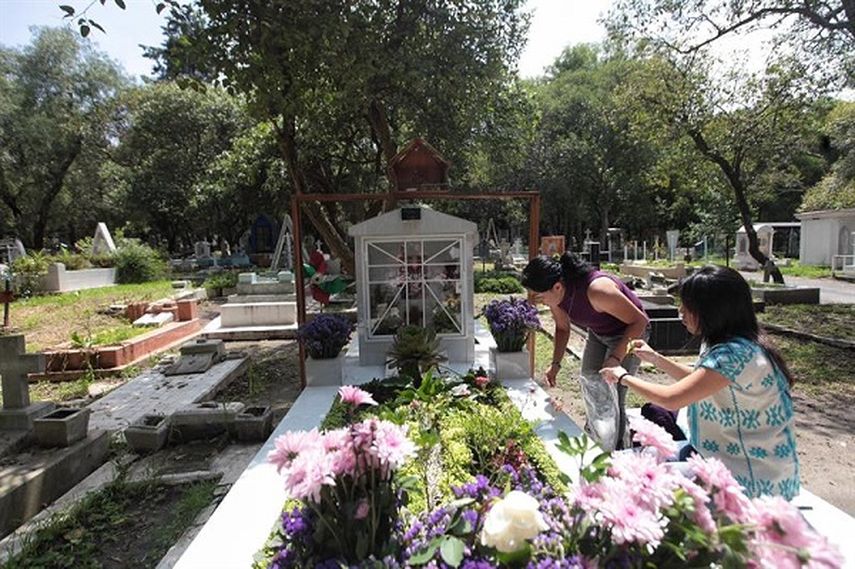 Alma (i) y Patricia Espinosa (d) visitan la tumba de su hermano, el fotógrafo Rubén Espinosa, en Ciudad de México (EFE)