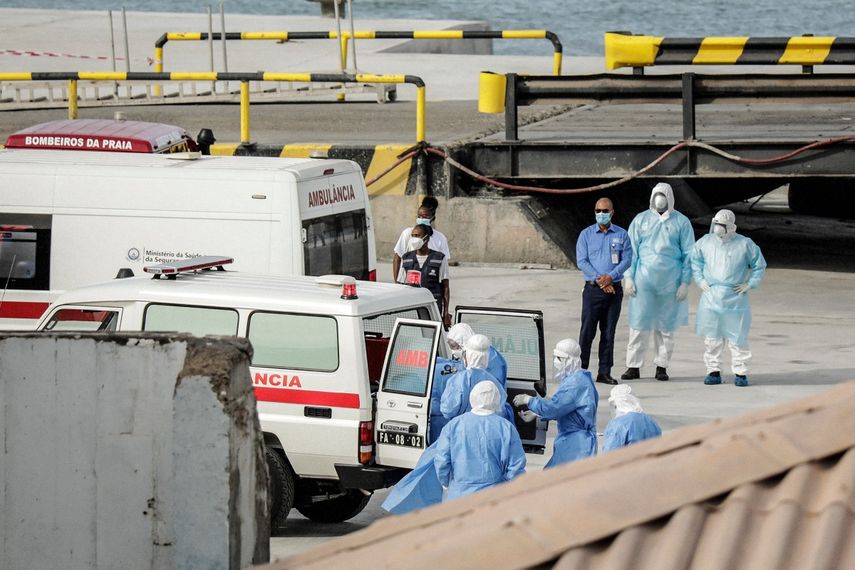 Personal sanitario que regresa del crucero MV Hondius es visto en el puerto de Praia, la capital de Cabo Verde, mientras se ayuda a subir a una ambulancia a personas que visten trajes de protección biológica, el 6 de mayo de 2026.