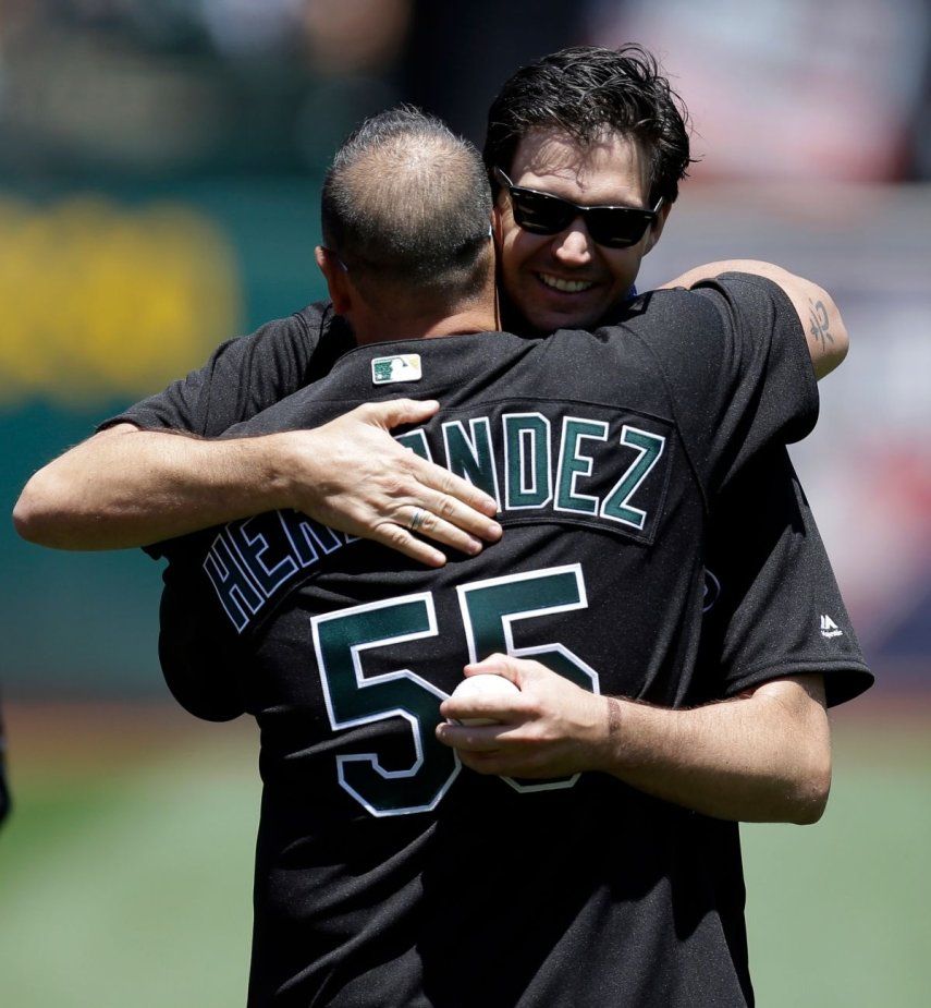 El exlanzador de los Atléticos de Oakland, Barry Zito, abraza al venezolano Ramón Hernández luego de realizar el pitcheo ceremonial, el 1 de julio de 2017.