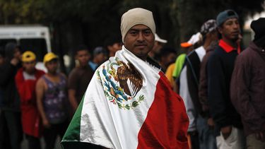 Un migrante hondureño, que integra la caravana que pretende llegar a Estados Unidos, se arropa con una bandera mexicana.