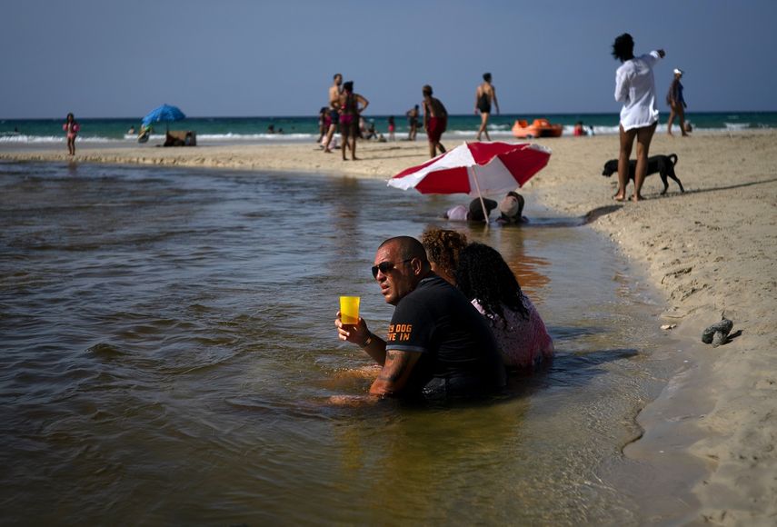Un grupo de cubanos&nbsp;se refrescan en las aguas poco profundas de las playas del litoral norte, al este de La Habana, Cuba, el jueves 18 de julio de 2019.