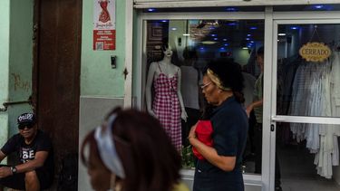 Residentes pasan junto a una tienda privada de ropa cerrada en La Habana, Cuba, el 11 de noviembre de 2023. En los últimos meses, en toda la isla han surgido decenas de negocios bautizados como “mipymes”, que ofrecen verdaderos tesoros, aunque a precios elevados para la mayoría de la población. 