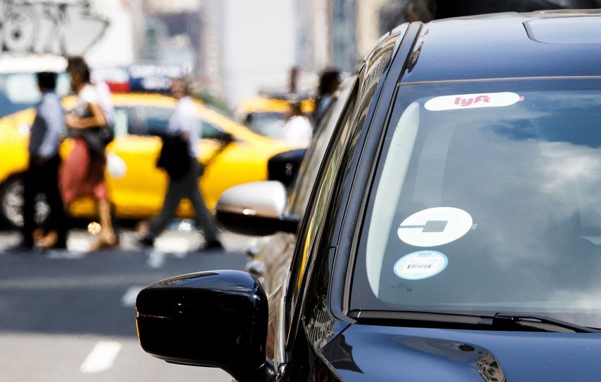 Imagen de archivo de un auto con los logotipos de las empresas de servicio de transporte compartido Uber y Lyft que recorre una de las calles de Nueva York.