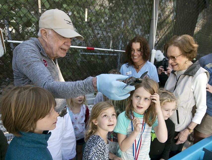 El expresidente Jimmy Carter sostiene en su mano una tortuga.&nbsp;