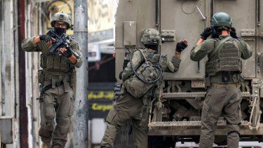 Un soldado del ejército de Israel llama a la puerta trasera de un vehículo blindado durante una operación militar en Nablus, en Cisjordania, el 8 de abril de 2025.