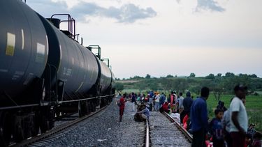 Migrantes ven pasar un tren mientras esperan a lo largo de las vías con la esperanza de subir a un tren de carga que vaya hacia el norte, el 19 de septiembre de 2023, en Huehuetoca, México.