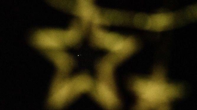 Una gran conjunción de los planetas Júpiter (Izquierda) y Saturno que se produce después de casi 400 años se ve detrás de las decoraciones navideñas en el cielo nocturno sobre la isla de Koh Lipe el 21 de diciembre de 2020.