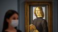 En esta foto de archivo, un empleado de Sothebys con una mascarilla o cubierta debido a la pandemia del COVID-19, posa para una fotografía con la obra de arte Joven sosteniendo un rodete del pintor renacentista italiano Sandro Botticelli, durante una sesión fotográfica en los subastadores de Sothebys en Londres el 2 de diciembre de 2020.&nbsp;