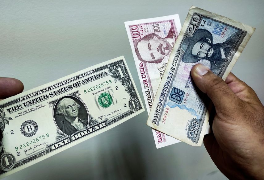 Un hombre muestra un dólar y pesos cubanos en La Habana, el 4 de agosto de 2022.